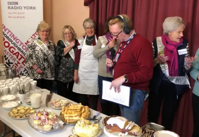 Adam Tomlinson and a table of cakes