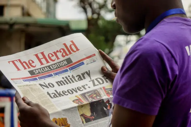 A man reads the front page of a special edition of The Herald newspaper about the crisis in Zimbabwe with the headline 'No military takeover - ZDF' on November 15, 2017 in Harare.