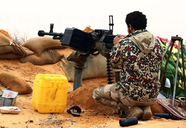 A fighter from the Fajr Libya (Libya Dawn) militia aims his weapon during clashes with forces loyal to Libya's internationally recognised government near the Wetia military air base, as they fight for control of the area some 170 kilometres west of the capital Tripoli on December 29, 2014