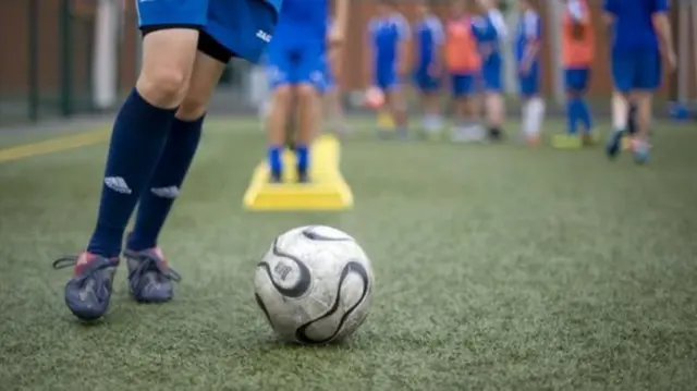 Boy playing football generic