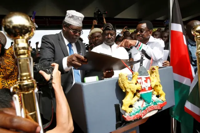 Kenyan opposition leader Raila Odinga (C) of the National Super Alliance (NASA) is assisted by lawyer Miguna Miguna (L) and James Orengo as he takes a symbolic presidential oath of office in front of his supporters in Nairobi, Kenya January 30, 2018.