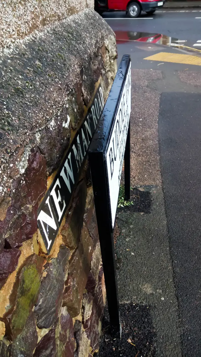 Sign reading "Buddle Road" with sign reading "Newman Road" behind