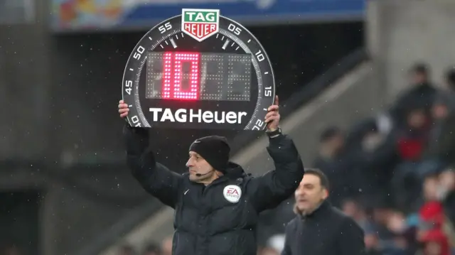 The fourth official indicates ten miNutes injury time