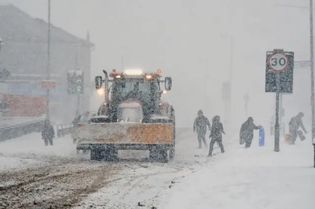 A snowplough clears the road in Balloch, Scotland