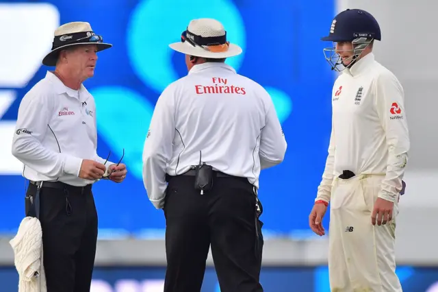 Umpires Bruce Oxenford and Marais Erasmus confer with England captain Joe Root