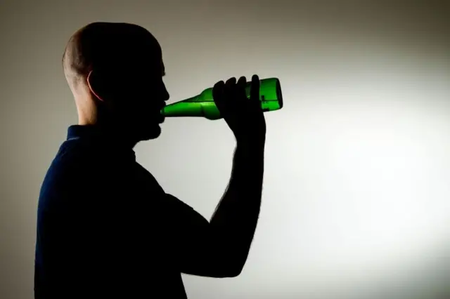 Man drinking a bottle of beer.