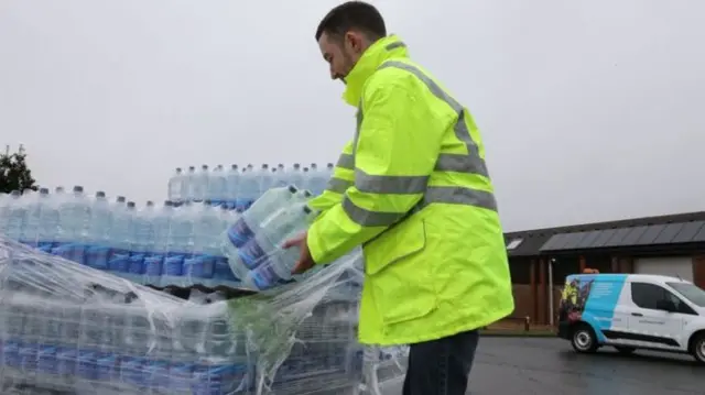 Man handing out bottled water