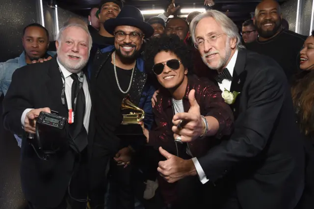Neil Portnow (far right) alongside Bruno Mars and one of his six Grammy awards