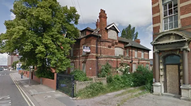 Derelict Farnhurst Resource Center with windows boarded up.