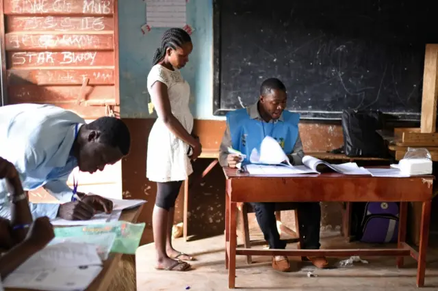 A woman casts her vote at a polling station during Sierra Leone's general election in Freetown, Sierra Leone