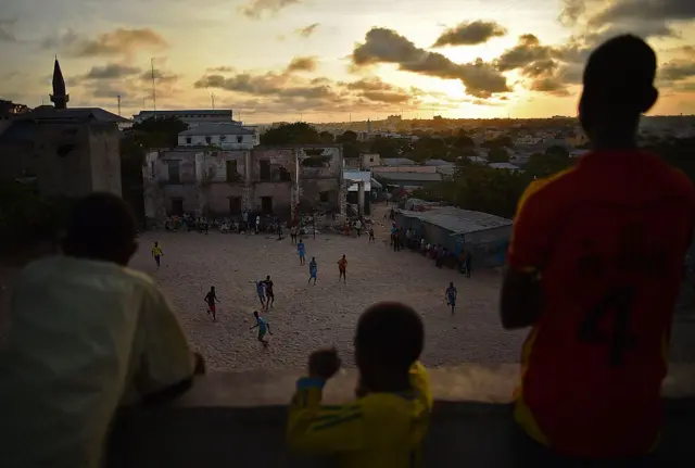 Children watch a football game in Mogadishu, Somalia