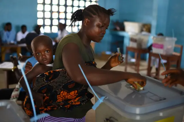 voter casts her ballot at a polling station during Sierra Leone"s general election in Freetown, Sierra Leone March 7, 2018