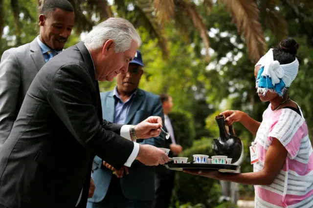 .S. Secretary of State Rex Tillerson (L) receives a cup of brewed coffee during a traditional coffee ceremony at the U.S. embassy in Addis Ababa on March 8, 2018