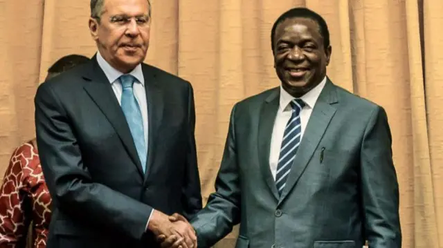 Russia's Foreign Minister Sergei Lavrov (L) shakes hands with Zimbabwe's President Emmerson Mnangagwa (R) at his Munhumutapa Offices in Harare on March 8, 2018. Lavrov is in Zimbabwe for bilateral and economic talks.