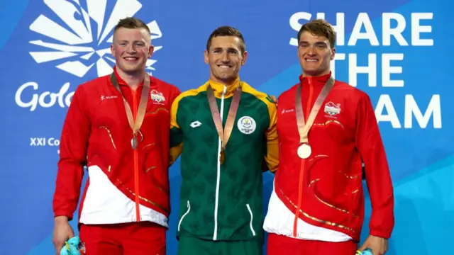 Adam Peaty and his swimming team mates collecting their medals