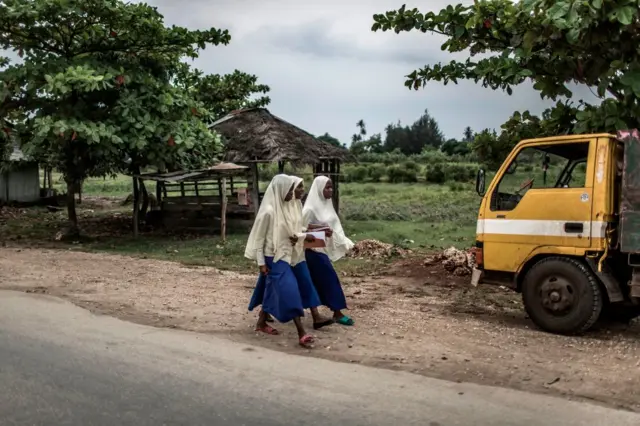 Girls wearing school uniforms are pictured after school in Matemwe, Zanzibar, on January 5, 2018.