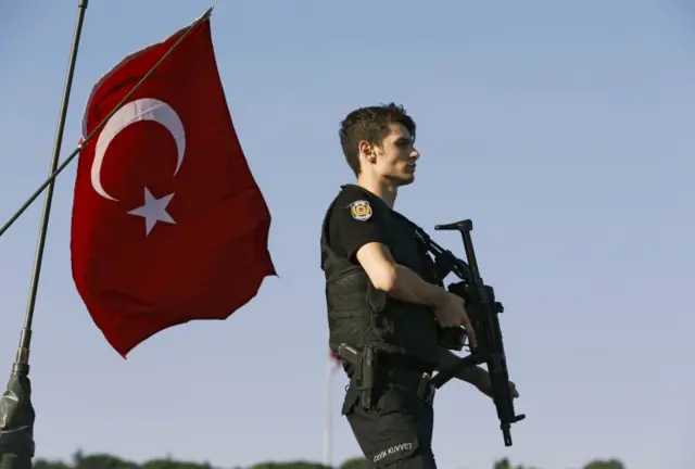 A policeman stands atop of a military armored vehicle after troops involved in the coup surrendered on the Bosphorus Bridge in Istanbul, Turkey July 16, 2016.