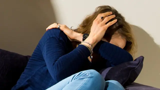 woman crouched on sofa