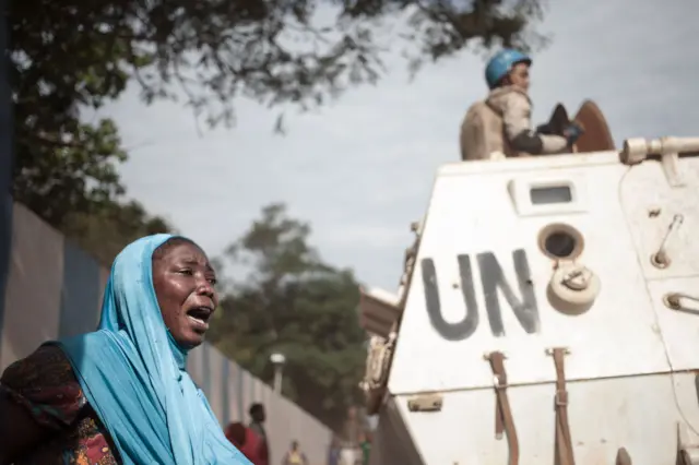 A woman reacts next to UN soldiers as inhabitants of the mainly Muslim PK5 neighbourhood demonstrate in front of the headquarters of he UN peacekeeping mission in the Central Africa Republic, in Bangui, on 11 April 2018