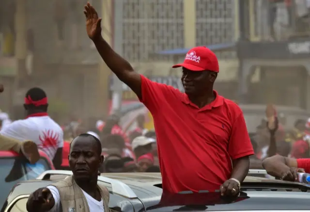 Samura Kamara (R) waves to supporters during a campaign rally on March 5, 2018 in Makeni, northern Sierra Leone.