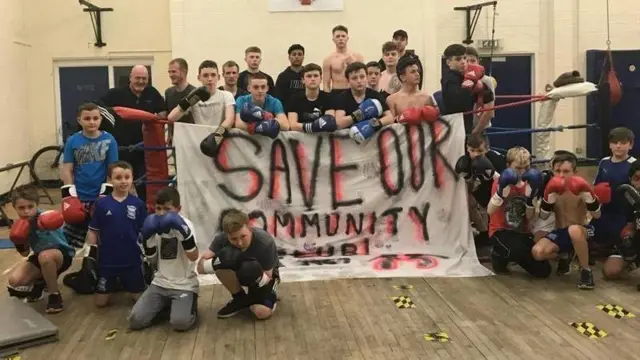 Children at the boxing club around a sign