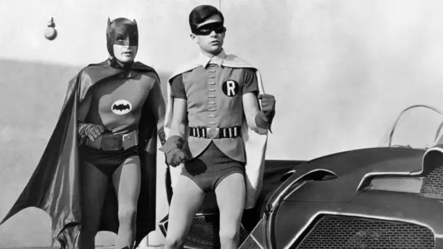 Actor Adam West as Batman (left) and Burt Ward as Robin, pictured with the Batmobile