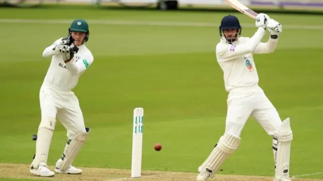 Hampshire"s James Vince hits four runs as Worcestershire"s wicketkeeper Ben Cox looks on