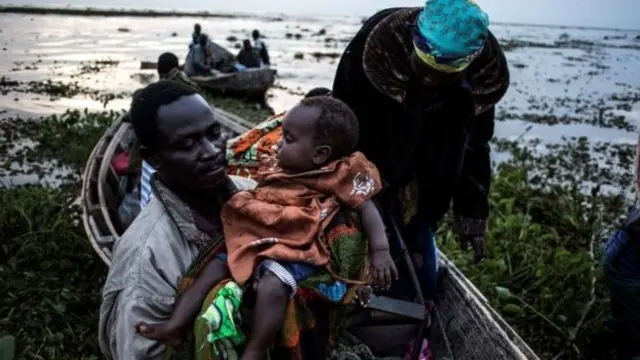 People in a boat fleeing their homes in DR Congo