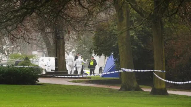 Part of West Park with police officers inside tape