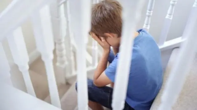 A boy sits on a stair