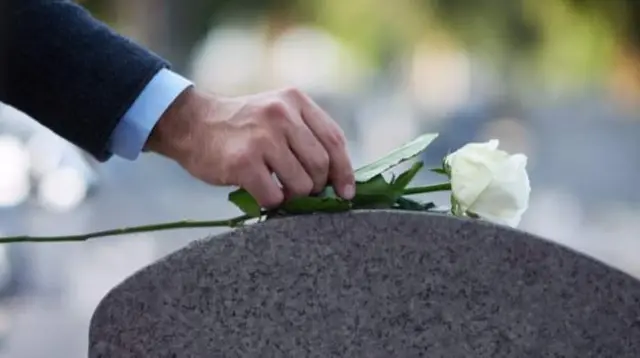 Flowers being placed on gravestone