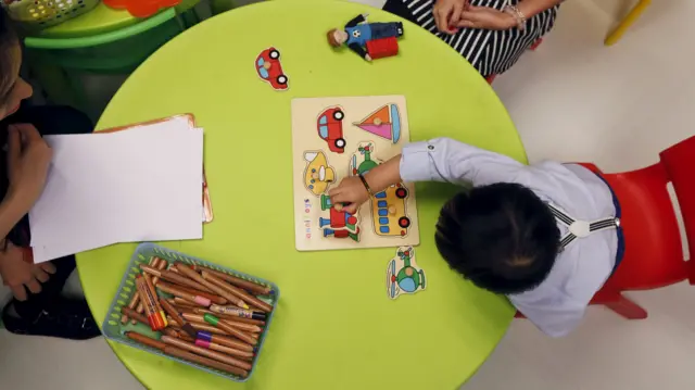 Children doing a puzzle and colouring