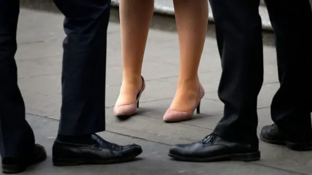 Legs of business woman and men