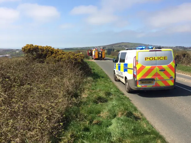 fire engine and police van parked on rural road