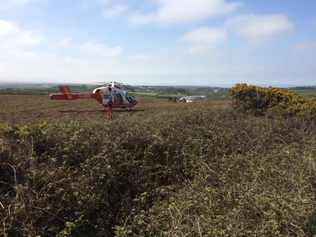 air ambulance and upturned plane in a field