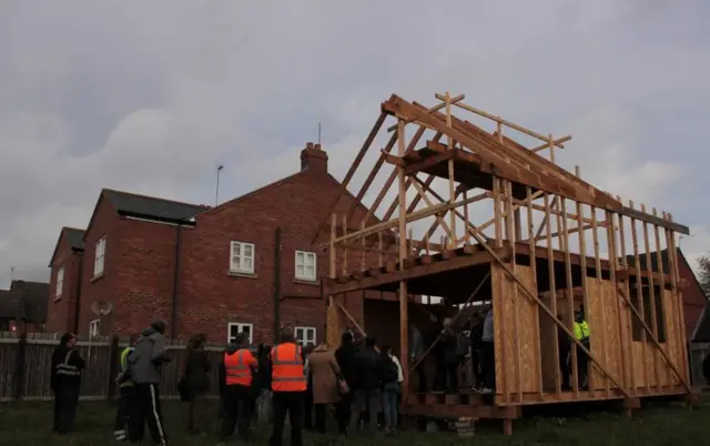 A timber frame being made into a house.