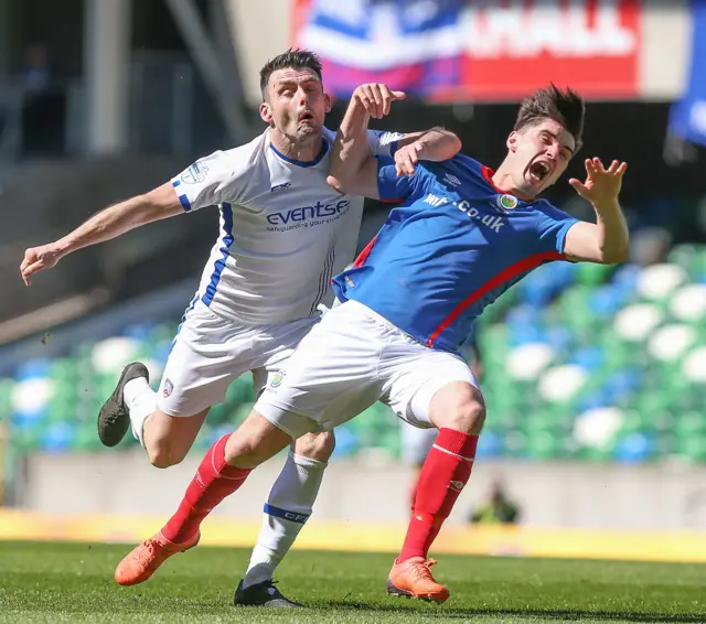 Coleraine forward Eoin Bradley sends Blues defender Jimmy Callacher tumbling