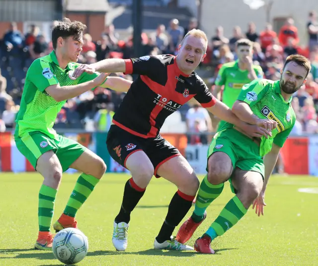 Jordan Owens in the thick of the action for Crusaders against Cliftonville.