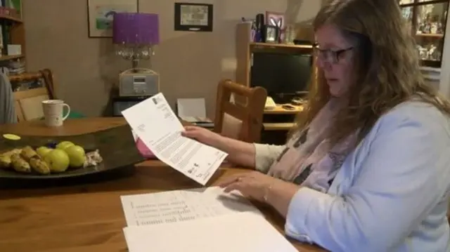 Tina Trowhill looks at papers on a table