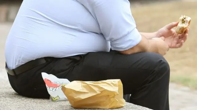 An overweight man eating