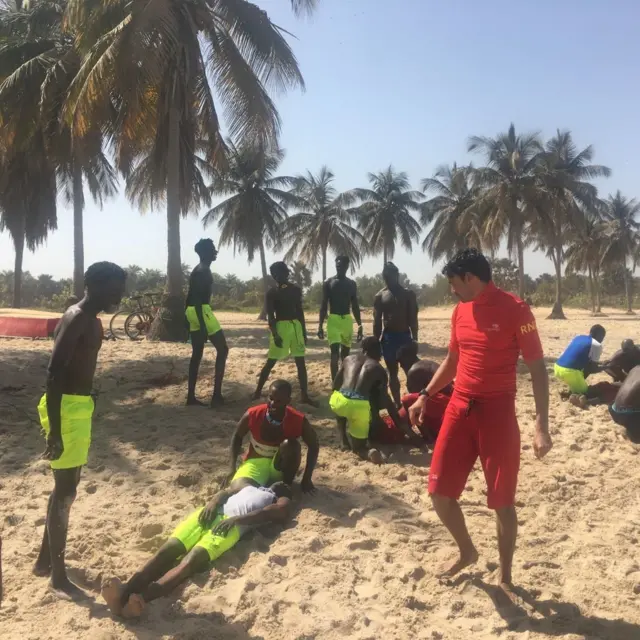 people practicing lifesaving techniques on a beach