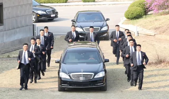 Security personnel accompany a vehicle transporting Kim Jong-un, 27 April