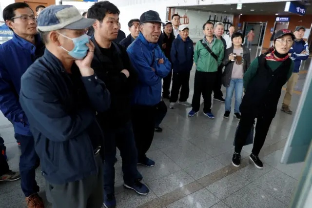 People watch TV screen in Seoul