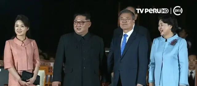 A still from TV Peru shows the leaders holding hands at the closing ceremony