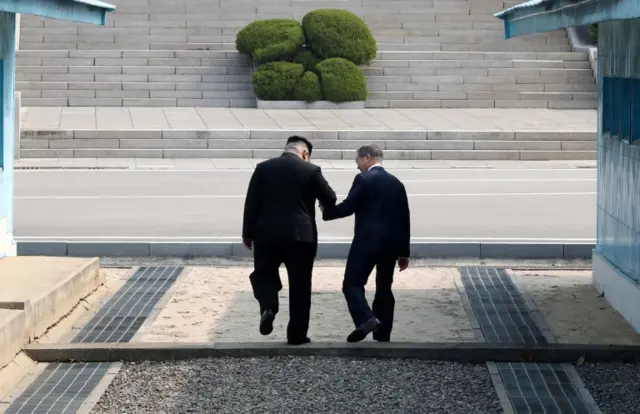 Kim and Moon cross the border holding hands