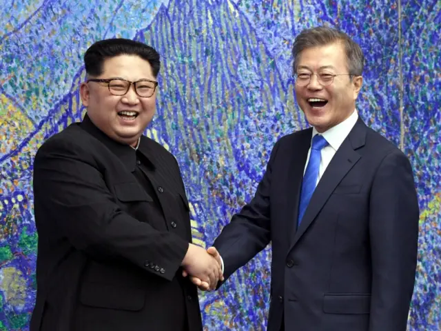 Kim and Moon shake hands and laugh