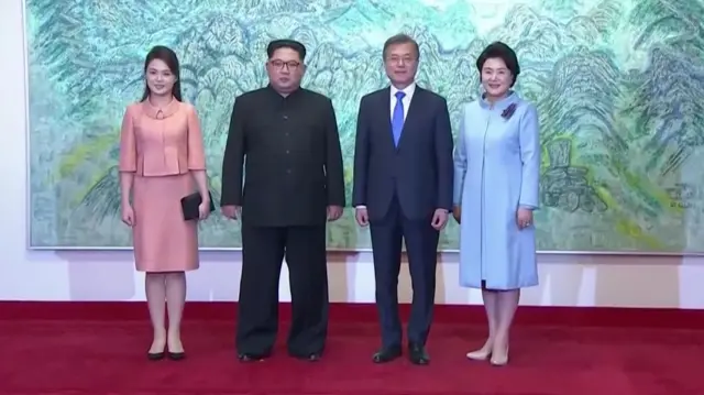 The two Korean leaders with their wives pose for a photo