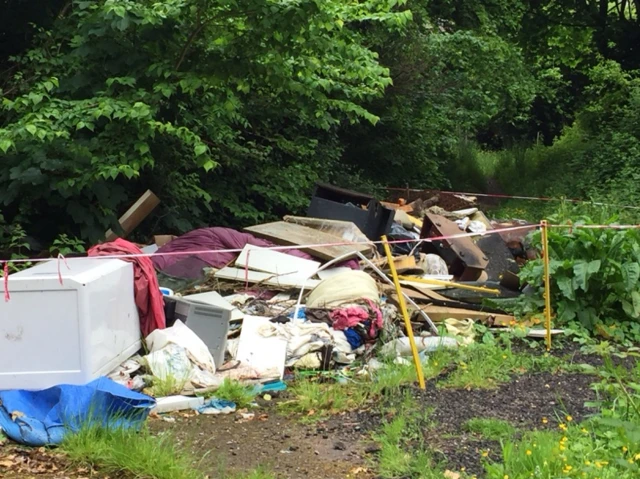 fly-tipped rubbish on rural footpath