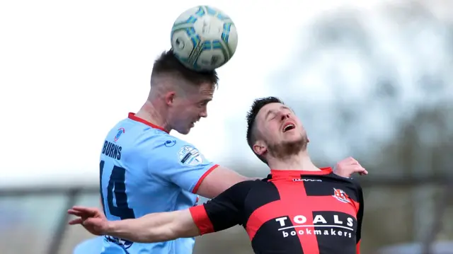 Ballymena United defender Andrew Burns wins an aerial tussle with Crusaders' Michael Carvill.