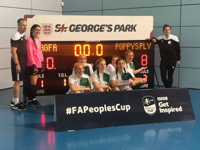 Poppy's Players in front of scoreboard